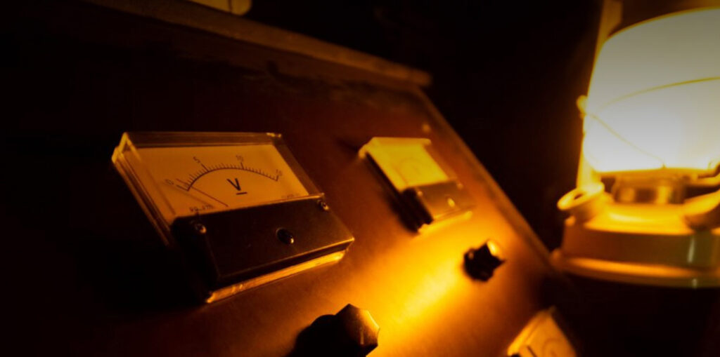An old fashioned electric light is lit up by a meter.